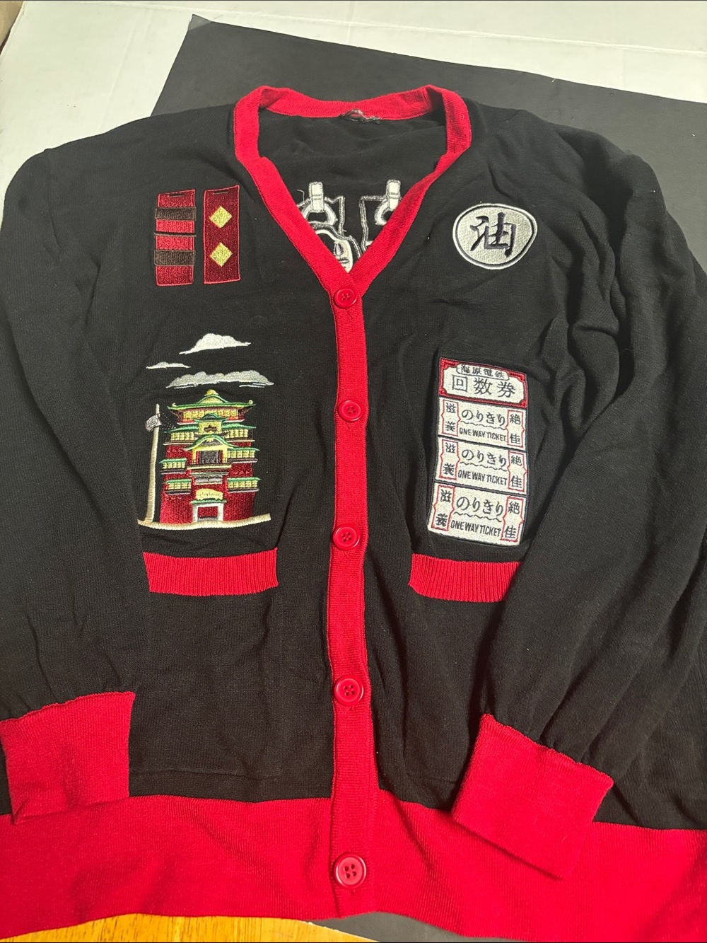 Woman’s  Black Cardigan Sweater with Red Trim and Embroidered Patches